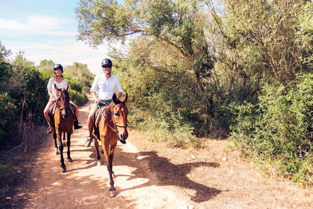 A couple horseback riding in Fredericksburg, TX.